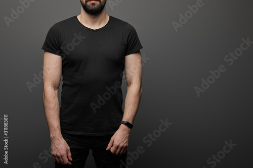 cropped view of bearded man in blank basic black t-shirt on black background