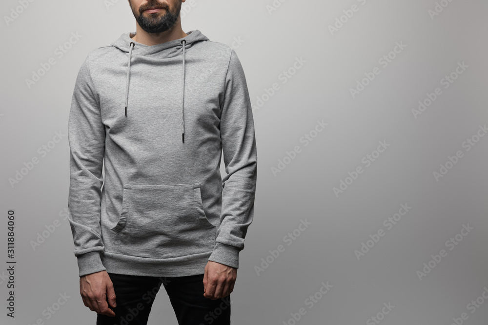 cropped view of bearded man in blank basic grey hoodie isolated on grey cropped view of bearded man in blank basic grey hoodie isolated on grey