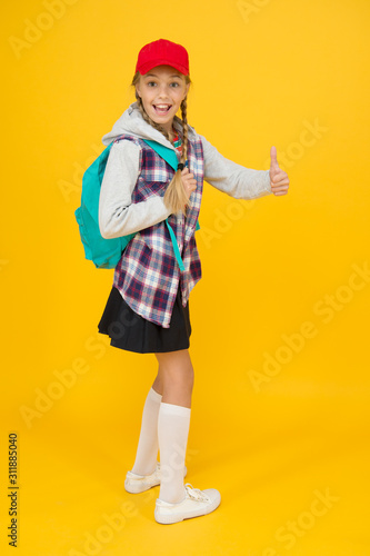 Cool schoolgirl. Happy childhood. Cute hipster teenager kid yellow background. Cheerful teenager. Small child girl long hair. Teens fashion. Teenager lifestyle. School days. Modern teenager