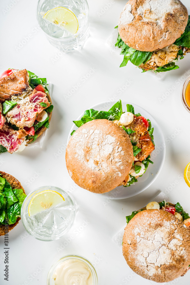 Various seafood and fish burgers assortment. Homemade healthy burger with grilled prawn, salmon, tuna, sea bass, fresh herbs, mozzarella cheese and baby spinach. Various seafood and fish burgers assortment. Homemade healthy burger with grilled prawn, salmon, tuna, sea bass, fresh herbs, mozzarella cheese and baby spinach.