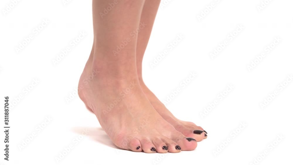 Side view of slim female feet with stylish black pedicure standing on toes. Isolated, on white background Side view of slim female feet with stylish black pedicure standing on toes. Isolated, on white background