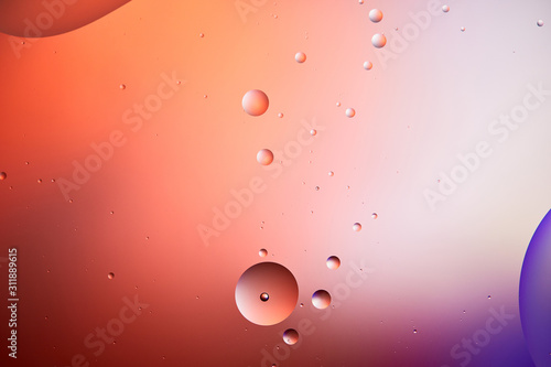 abstract creative background from mixed water and oil bubbles in red and purple color