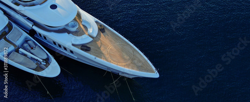 Aerial drone ultra wide photo of luxury yacht with wooden deck docked in tropical exotic destination photo
