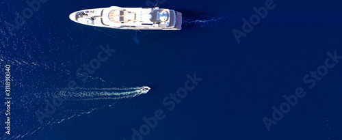 Aerial drone ultra wide photo of luxury mega yacht with wooden deck cruising Aegean deep blue sea