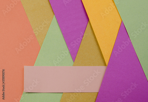 Layers of colored, rough textured construction paper creating a graphic template. Abstract design geometric style color blocks. Copyspace. Rainbow colors.