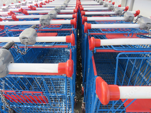 Rows of blue shopping carts collected in supermarket. Double lined shopping carts. photo