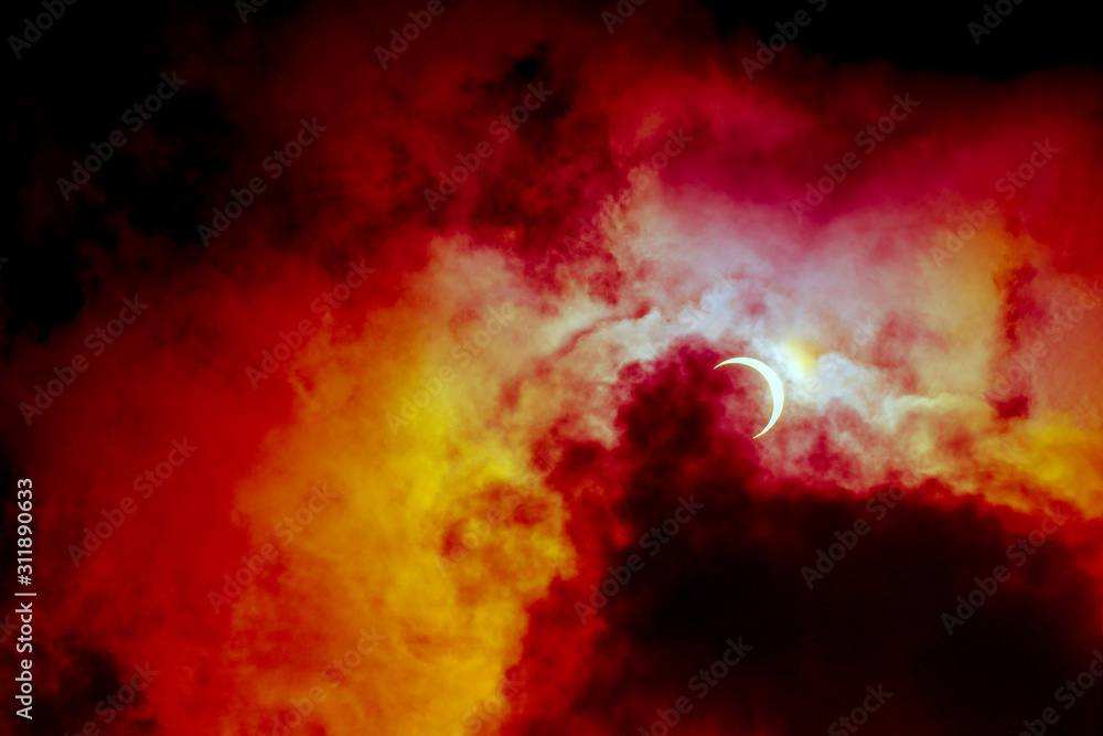 Partial annular solar eclipse, known in such circumstances as a ring of fire, seen in Malaysia in 26th Dec 2019. Cloudy weather in the Kuala Lumpur obscuring much of the view. Dramatic colour applied.