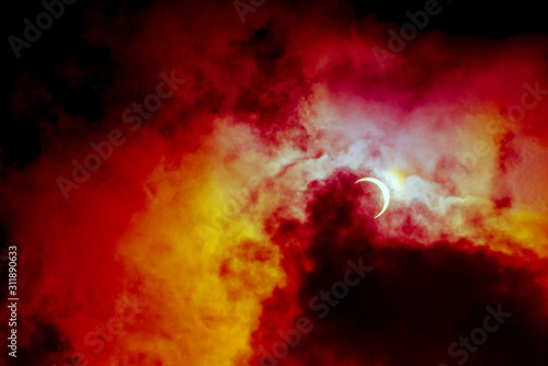 Partial annular solar eclipse, known in such circumstances as a ring of fire, seen in Malaysia in 26th Dec 2019. Cloudy weather in the Kuala Lumpur obscuring much of the view. Dramatic colour applied. © ShaifulZamri