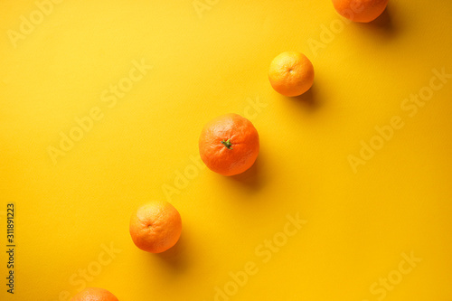 Orange tangerines on a yellow background with place for text. Flat lay.