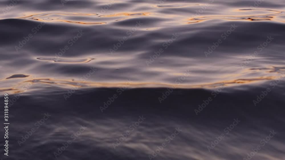 Close-up of the surface of the water in the river at sunset in the fall. Recorded in Raw on Blackmagic camera. Close-up of the surface of the water in the river at sunset in the fall. Recorded in Raw on Blackmagic camera.
