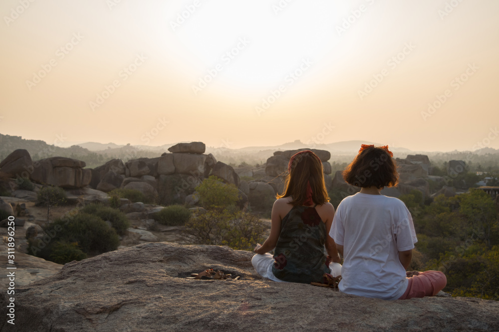 Two woman doing meditation in Hampi, Karnataka, India