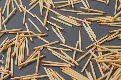 Scattered many matches with red sulfur on dark concrete desk on kitchen. Close-up