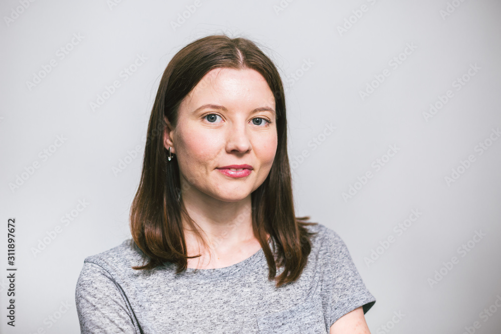 portrait of stylish young pretty Caucasian woman smiling in grey t-shirt on white studio background, isolated, natural look, long brown hair portrait of stylish young pretty Caucasian woman smiling in grey t-shirt on white studio background, isolated, natural look, long brown hair