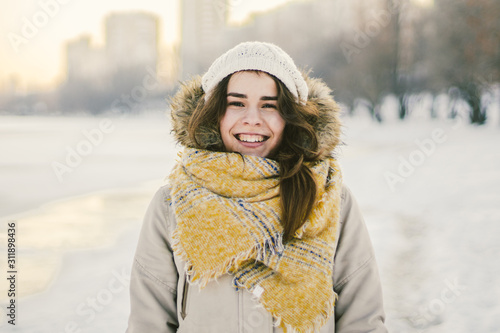 Beautiful happy laughing young woman wearing winter hat and scarf. winter background with snow. Winter holidays concept. Happy Woman In Winter Nature