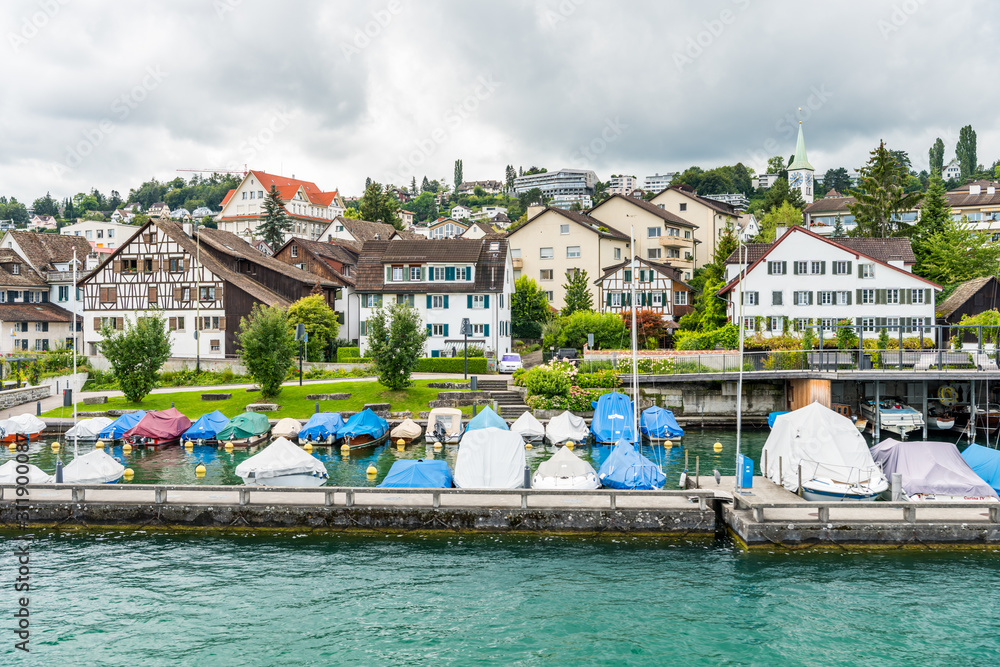 Boats parking on the lake of Zurich, with background of beautiful building on the lakeshore in Zurich, Switzerland.
