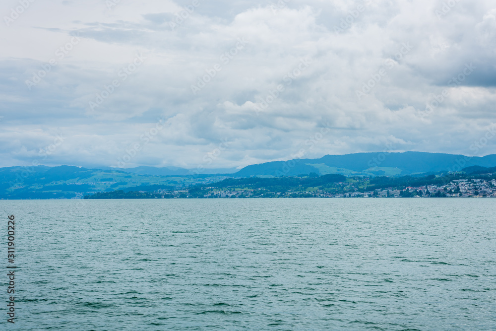 Beautiful lake Zurich landscape. Cloudy skyscape with  background of Alps mountains peaks.