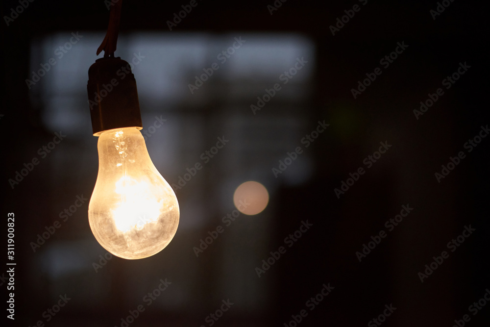 Warm light bulb in a dark space Warm light bulb in a dark space