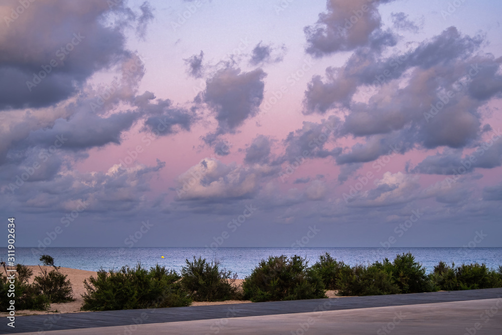 Fototapeta premium Pink sky with clouds over the sea during the sunset at the beach.