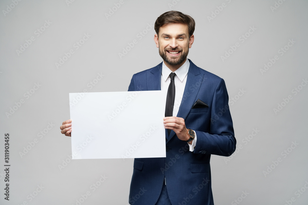 Young businessman holding blank signs over grey background Young businessman holding blank signs over grey background