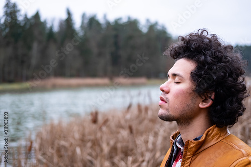 Latin American man looking relaxed at a lake 
