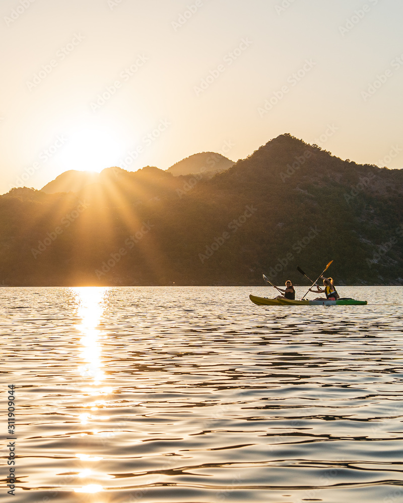 Φωτογραφία Backlit active couple doing kayak at sunset (sunrise) in lake skadar, (Scutari Shkodër Shkodra) on the border of Albania and Montenegro