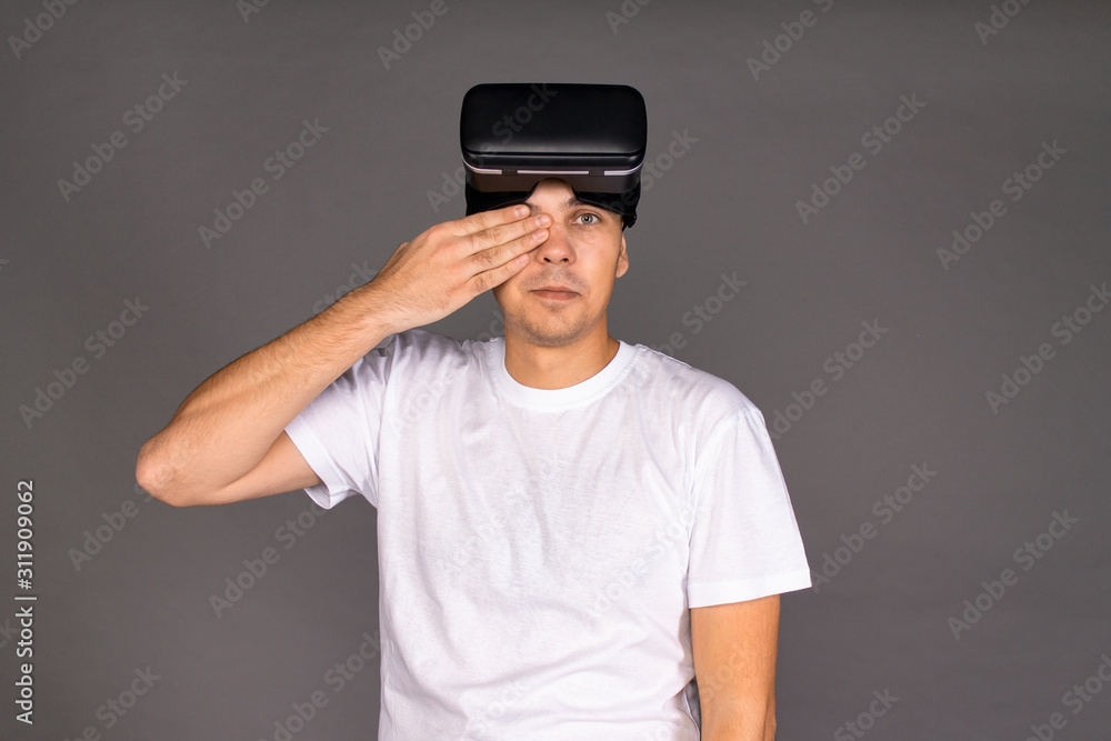 Portrait of a guy in virtual reality glasses that compares the real and virtual world. Future and modern technologies Portrait of a guy in virtual reality glasses that compares the real and virtual world. Future and modern technologies