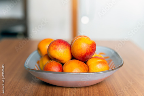 Fototapeta Naklejka Na Ścianę i Meble -  Ripe bright apricots on a table in a plate close-up