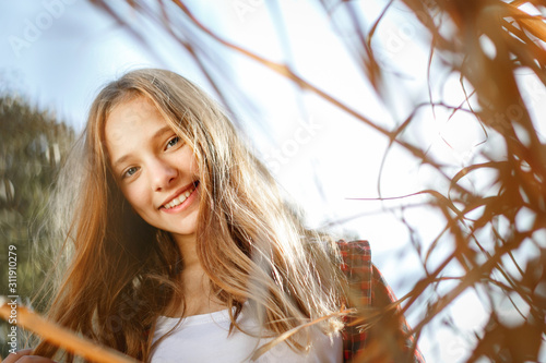 Lifestyle sunny outdoor portrait of young smiling teenage girl