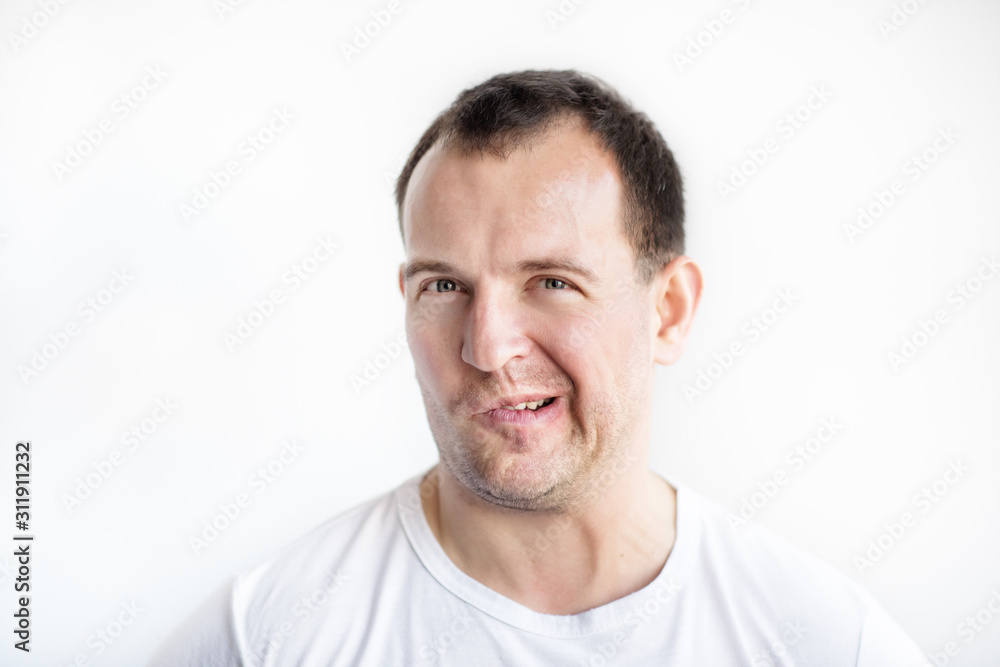 Closeup portrait of disgusted 30 years old caucasian white man on white background in white t-shirt. Man making weird face and looking in camera. Afraid, desperate, disgusted guy conceptual picture. Closeup portrait of disgusted 30 years old caucasian white man on white background in white t-shirt. Man making weird face and looking in camera. Afraid, desperate, disgusted guy conceptual picture.