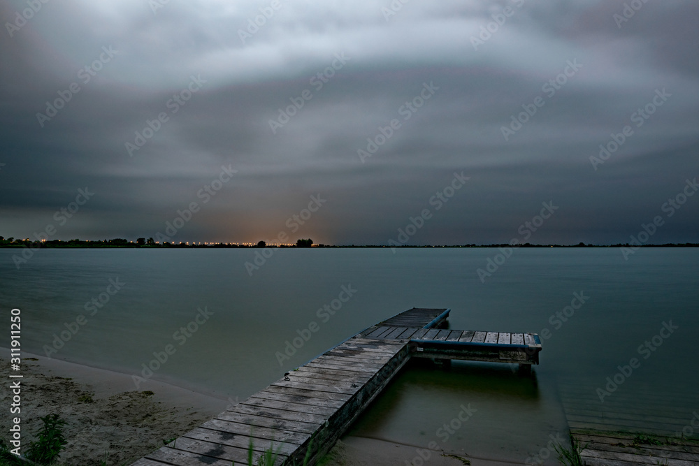 Dramatic sky as a severe summer thunderstorm is approaching over a lake in The Netherlands in the evening