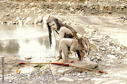 Φωτογραφία A young woman is  dressed as a neanderthal warrior