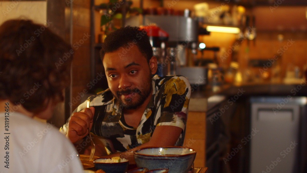 Two people sit at a table in a cafe, they eat food, drink tea and talk friendly Two people sit at a table in a cafe, they eat food, drink tea and talk friendly