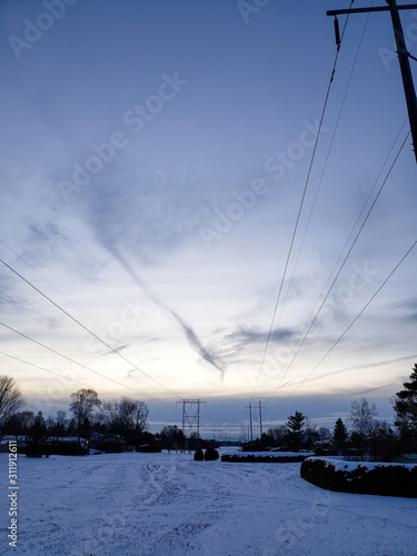 View down a trail with hydro lines over top in the winter in Canada near Ottawa.