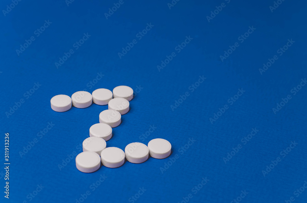 Letter Z made from white pills on a blue background