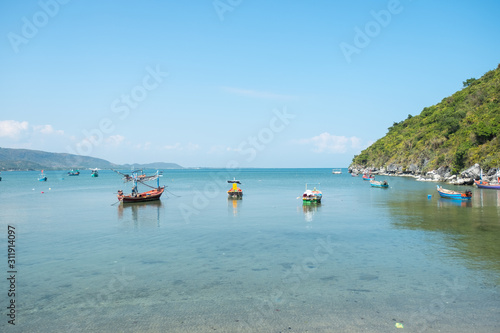 fisherman boats on the ocean with cliff and sky background in Thailand
