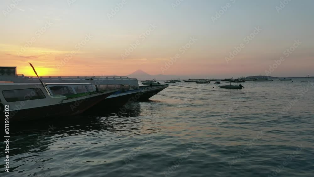Aerial departure from the beach, flying over boats in Indonesia towards the sunset. Aerial departure from the beach, flying over boats in Indonesia towards the sunset.