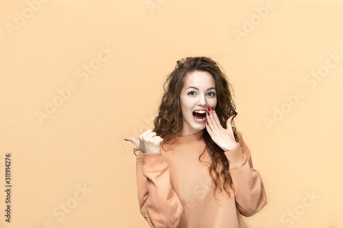 Portrait of a young beautiful woman wearing sweatshirt posing isolated over yellow background