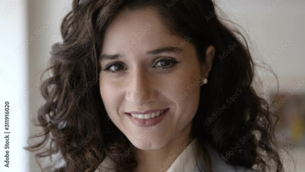 Closeup shot of smiling business expert posing indoors. Cheerful young woman standing and looking at camera. Business portrait concept Closeup shot of smiling business expert posing indoors. Cheerful young woman standing and looking at camera. Business portrait concept