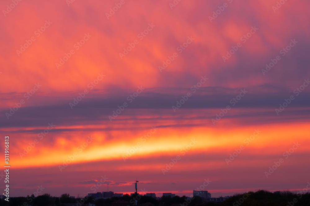 Houses in the distance on the horizon against the evening cloudy sky with spectacular bogrovoy sunset Houses in the distance on the horizon against the evening cloudy sky with spectacular bogrovoy sunset