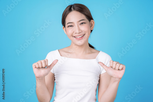 Photos Asian woman in a bright smile, proudly and loving herself on a blue background