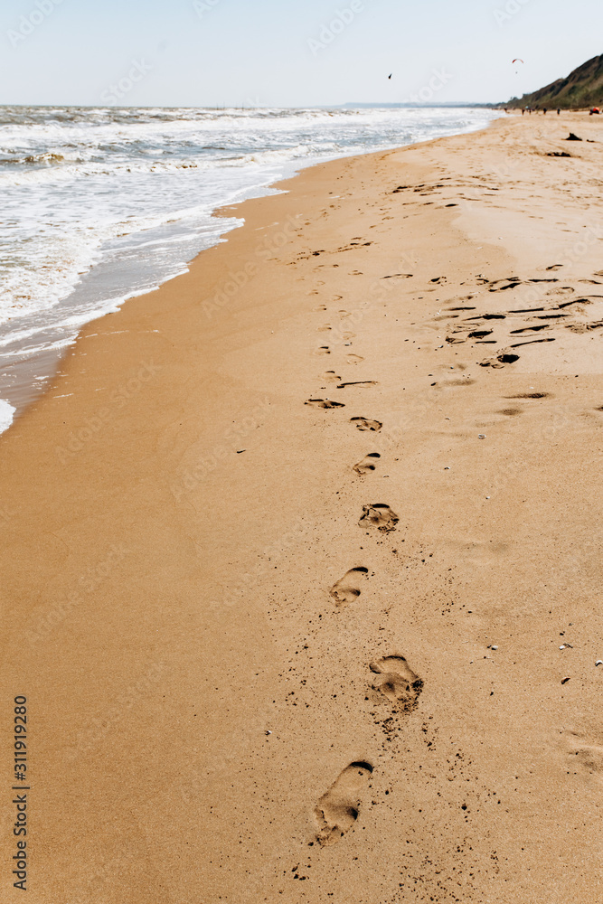 Footprints on beach background. A footprint of human feet on the sand near the sea Footprints on beach background. A footprint of human feet on the sand near the sea