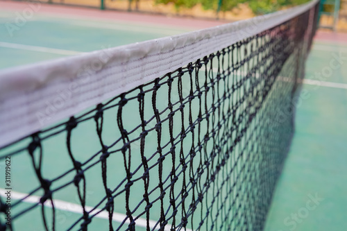tennis net on a green tennis court © cineos