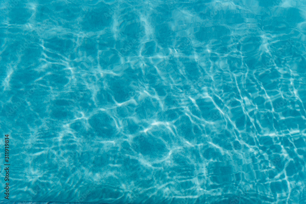 Beautiful refreshing blue swimming pool water. Background of blue water in the pool