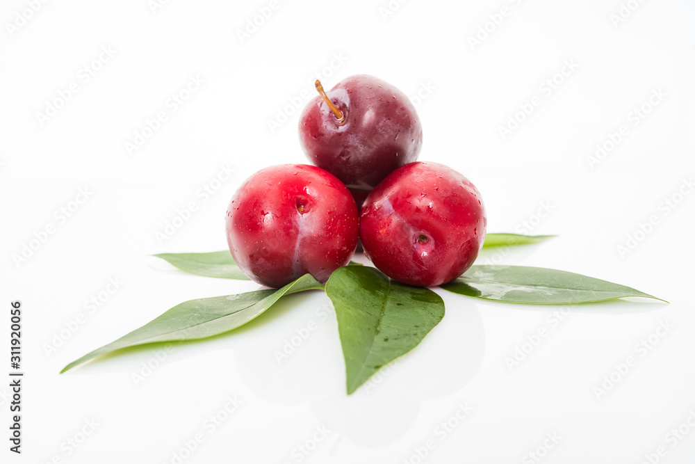 plums with plum leaves on a white background plums with plum leaves on a white background