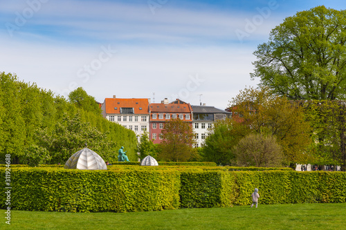 Kid playing in Rosenborg Castle Gardens (Kongens Have) in Copenhagen, Denmark on a sunny summer day photo