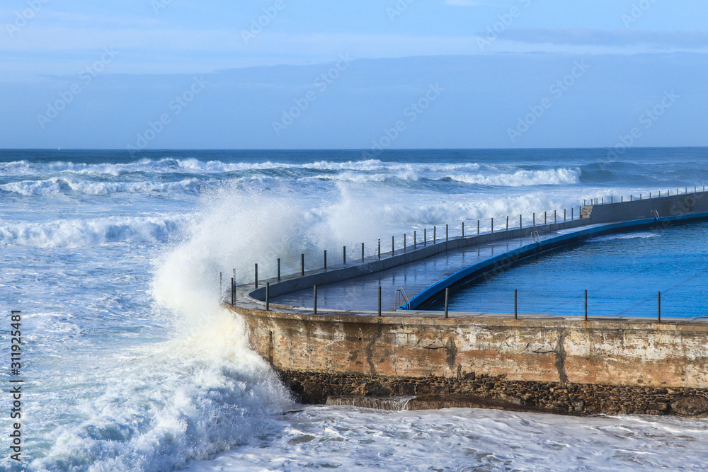 Big Wave crashes into the wall of an oceanic pool