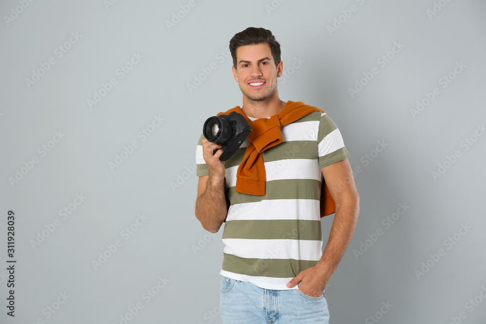 Professional photographer working on light grey background in studio Professional photographer working on light grey background in studio