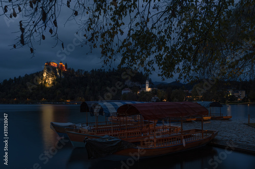 Obraz na płótnie The Pearl Of Slovenia's Nature, Amazing Lake Bled,Late Autumn. Early Morning With Overcast Sky And View Of The Bled Castle (Blejski Grad) And Marina With «Pletna» - Traditional Boats Such As Gondolas. w salonie