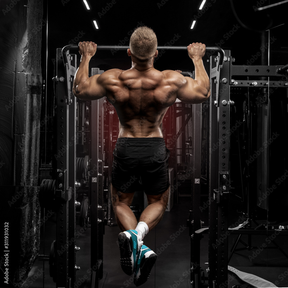 power muscular bodybuilder guy doing pullups in gym. Fitness man pumping up lats muscles. Fitness and bodybuilding training health lifestyle concept power muscular bodybuilder guy doing pullups in gym. Fitness man pumping up lats muscles. Fitness and bodybuilding training health lifestyle concept