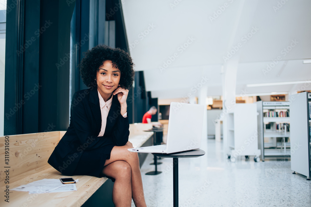 Portrait of female lawyer in trendy formal wear working on modern computer looking at camera, confident businesswoman spending time for research information on banking website using 4G internet